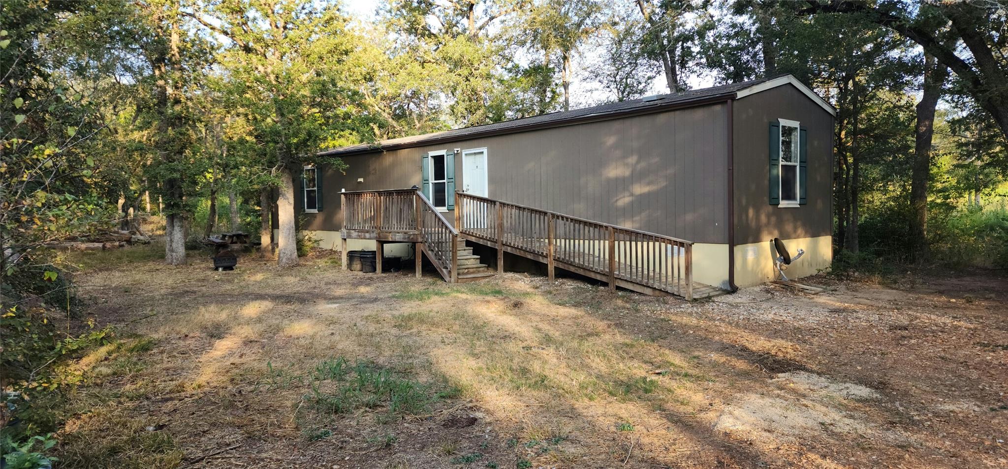 Mature trees surround this home featuring a woode