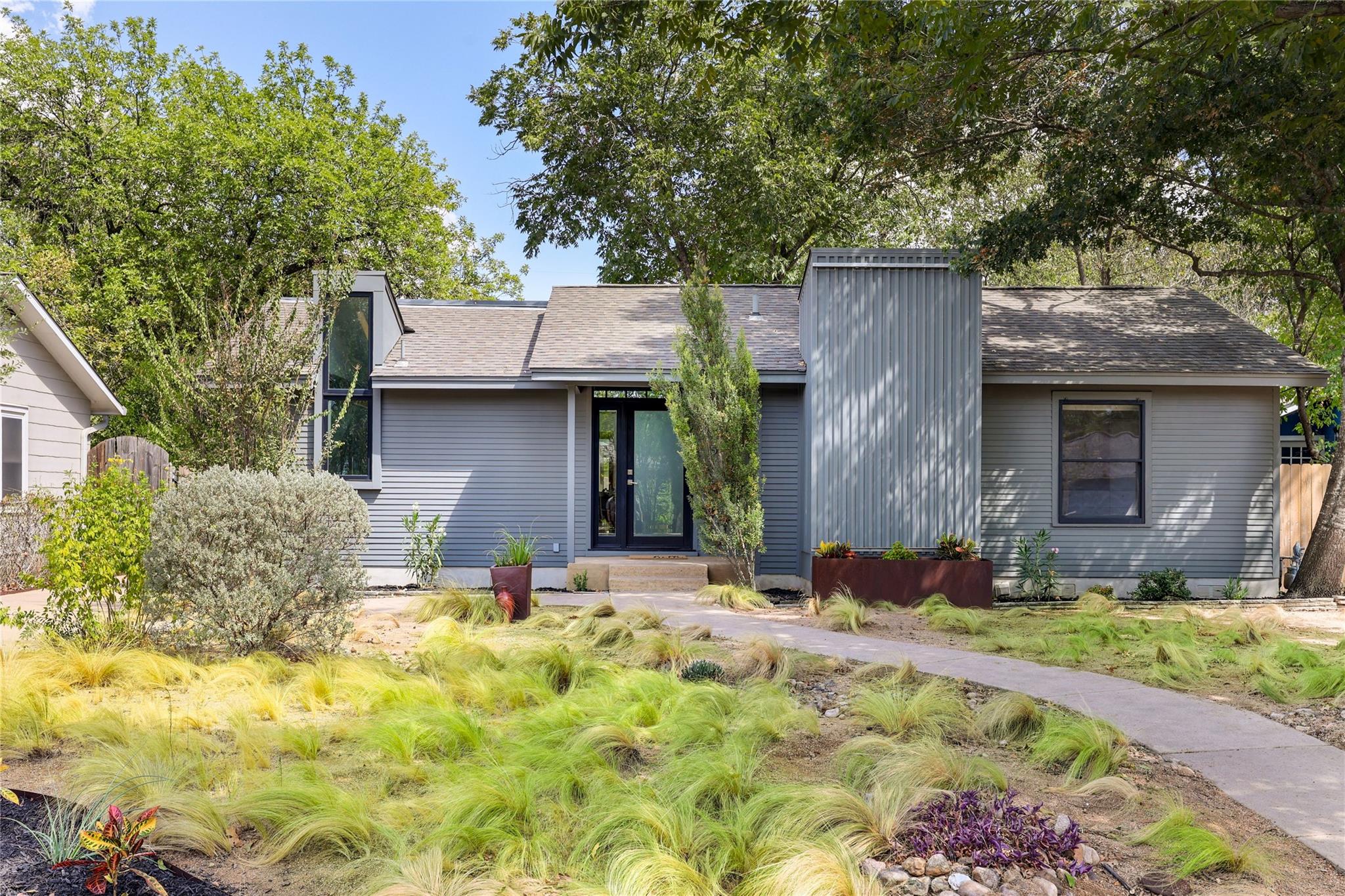 Mature trees frame the architectural lines of thi