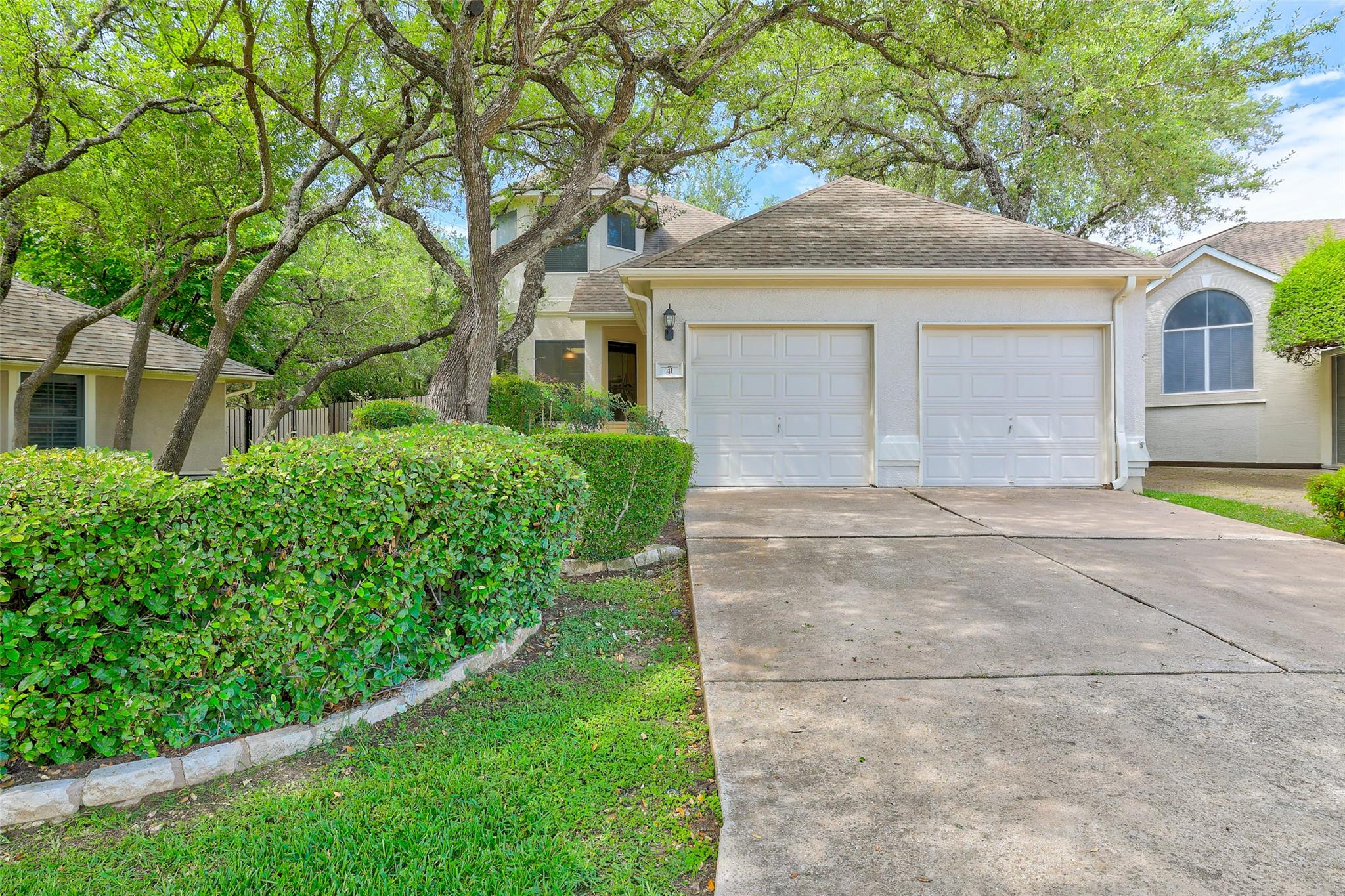 Mature trees shade a classic stucco exterior feat