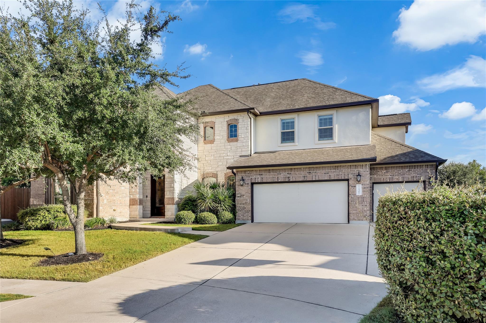 An elegant stone and brick exterior features a wi