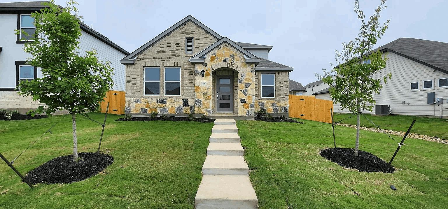 A concrete walkway leads past a grassy lawn to th