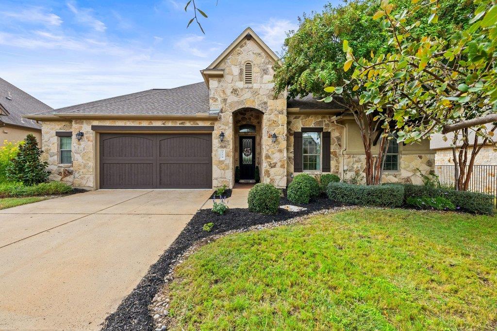 Natural stone masonry and a wide concrete drivewa