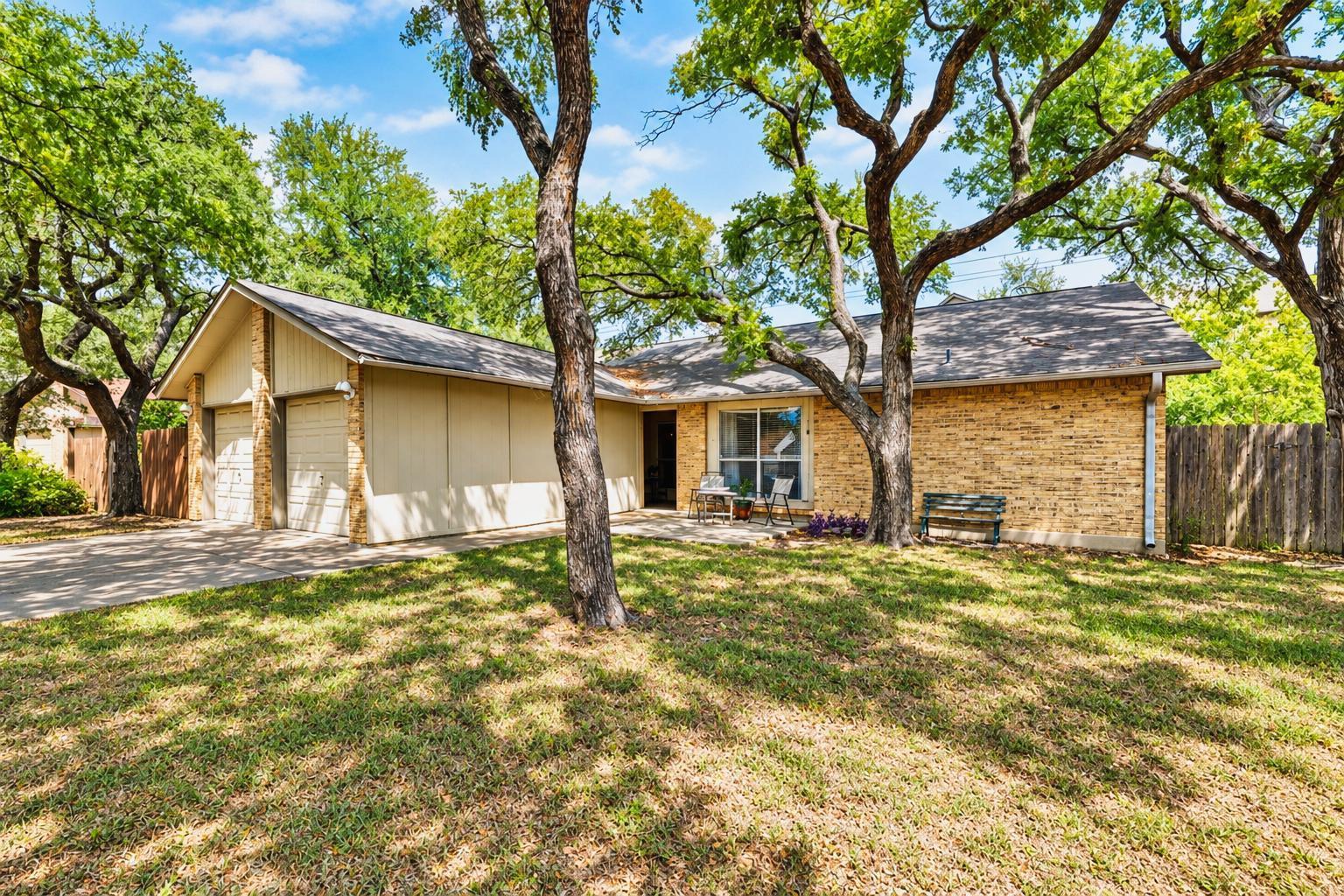 Mature trees shade a classic brick facade with a 