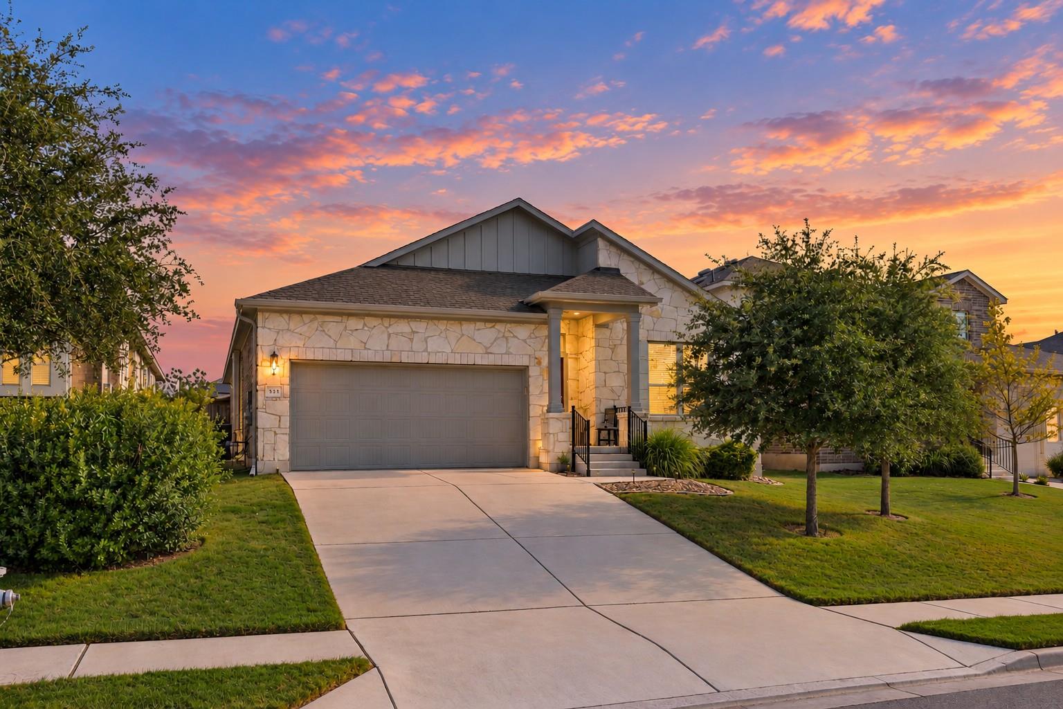Natural stone masonry and a wide concrete drivewa