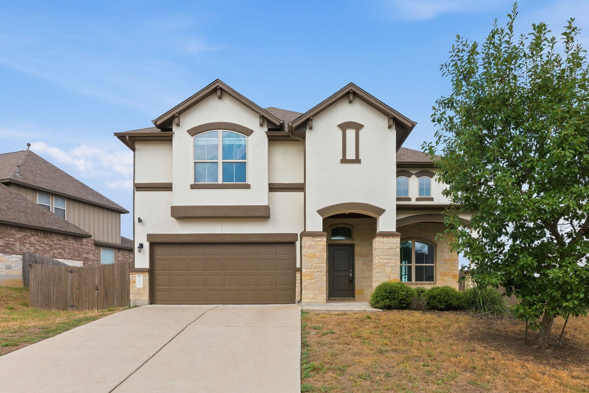 Stucco and stone detailing accents this two-story
