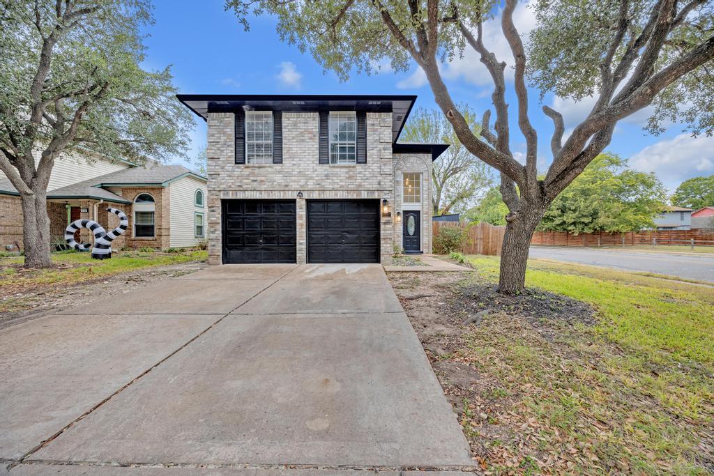Mature trees frame a classic brick exterior compl