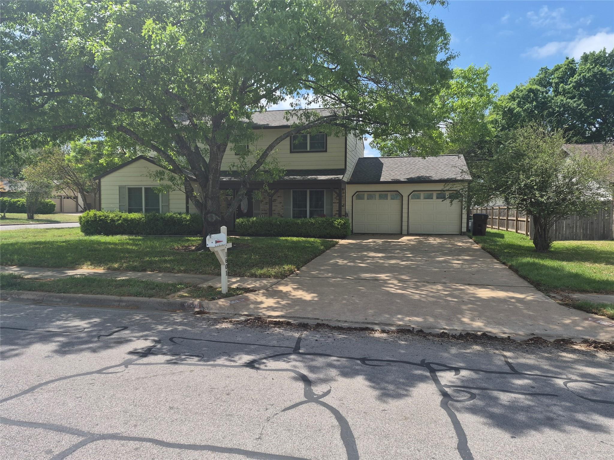 Mature trees shade the front lawn of this two-sto