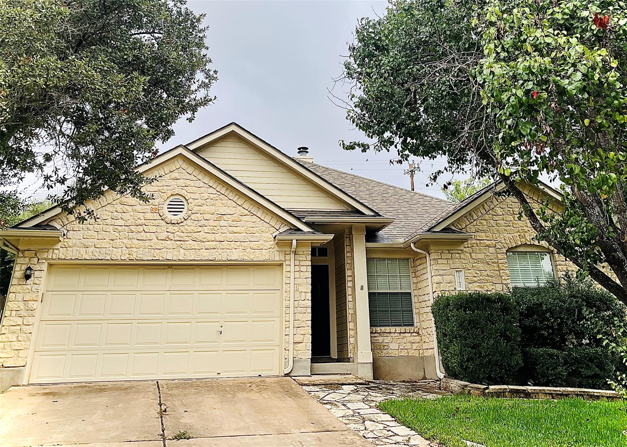 Mature trees shade a classic stone exterior with 