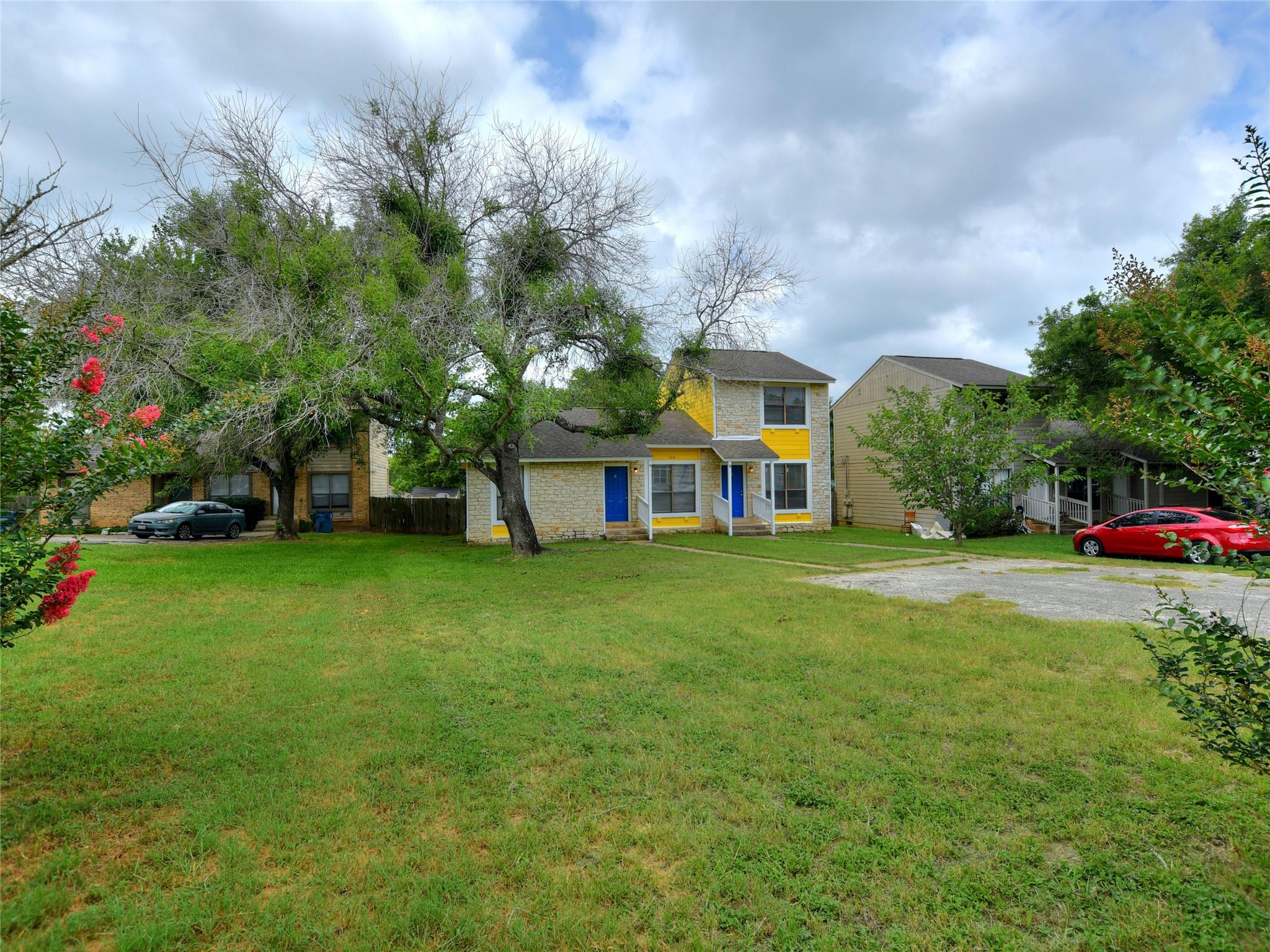 Mature trees shade a spacious green lawn leading 