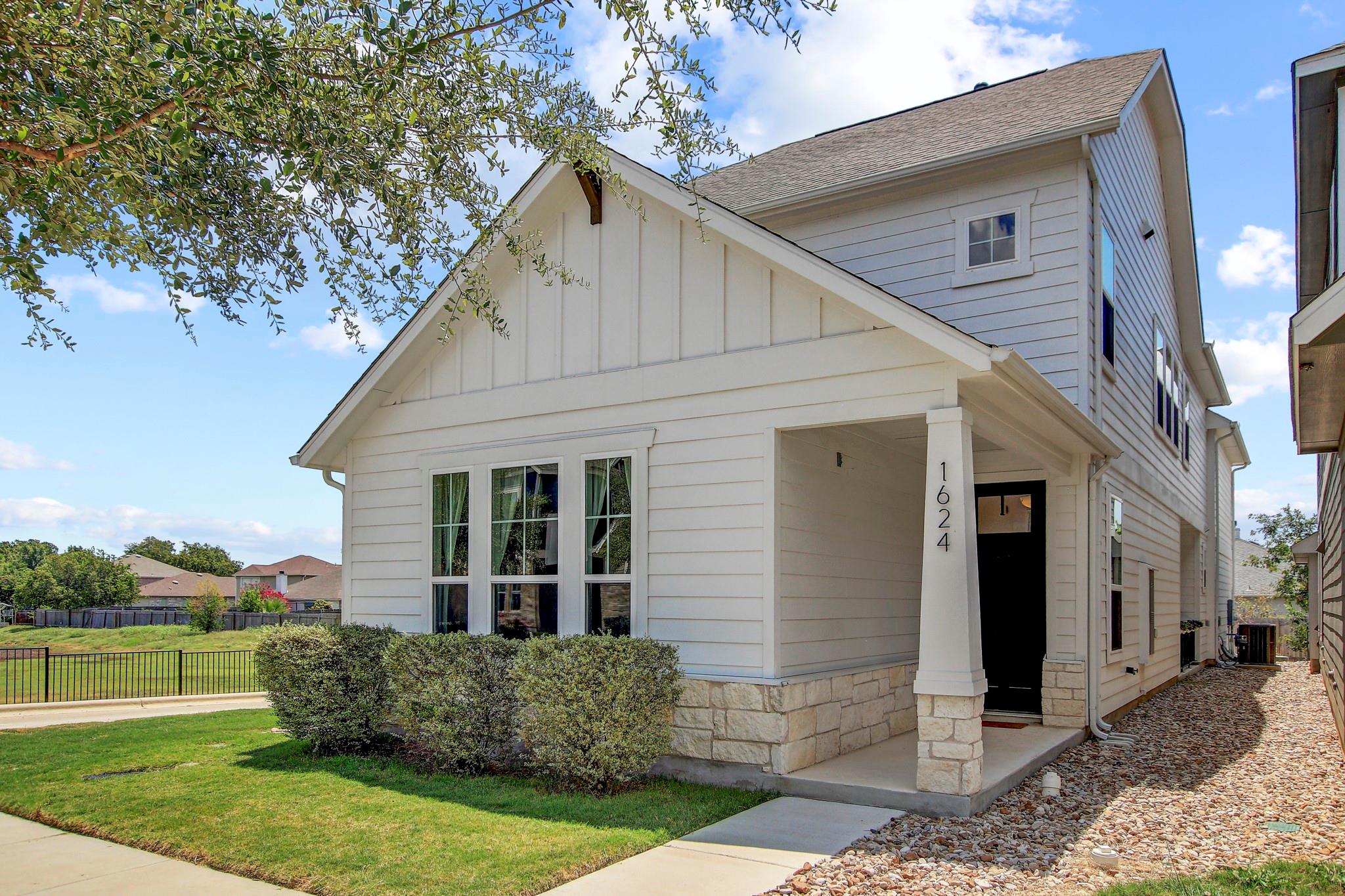 White siding and stone accents complement this ho