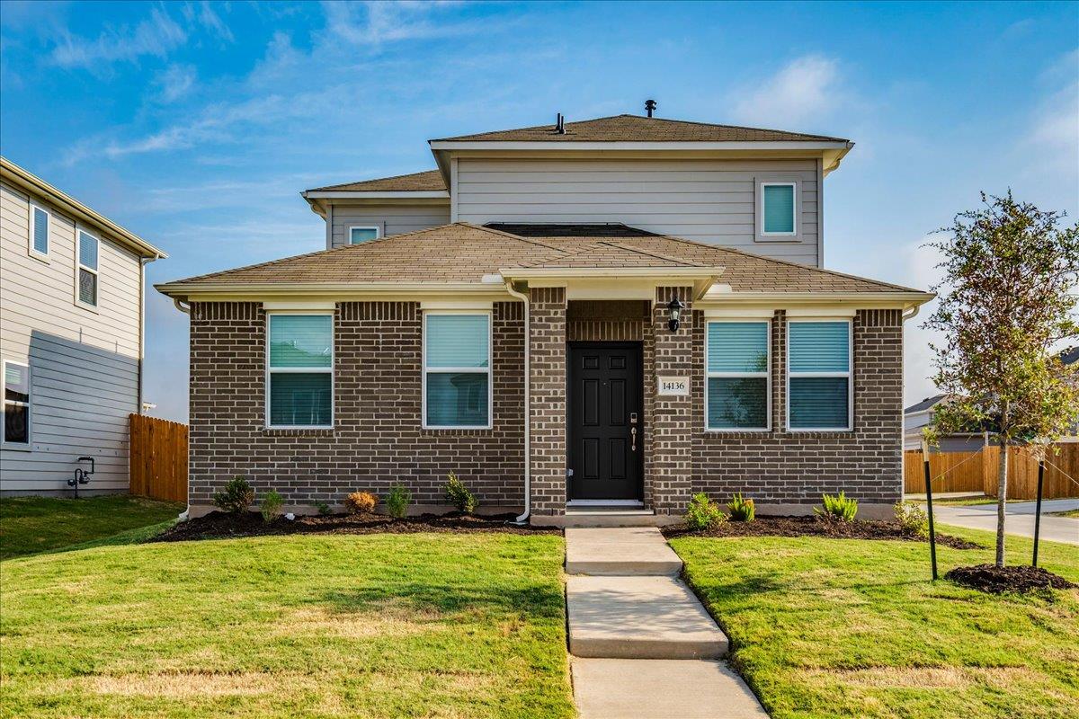 Classic brick accents and neat landscaping define
