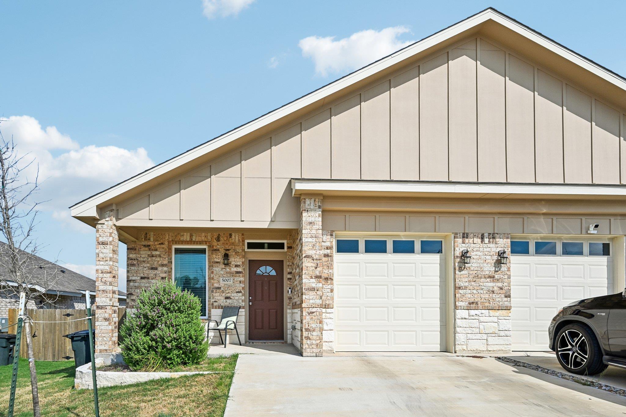 A classic brick facade and tidy driveway lend nea