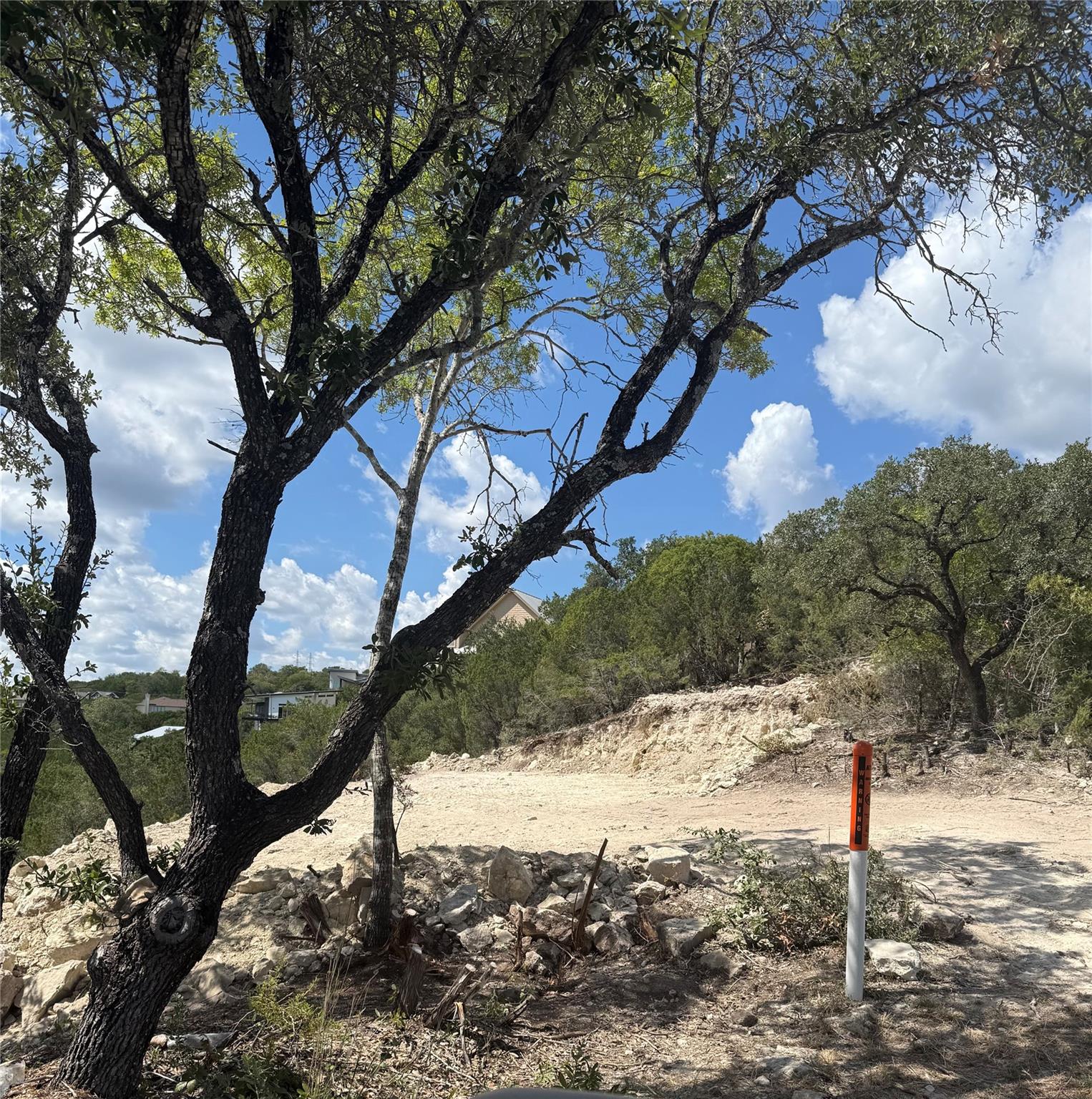 Mature trees frame a cleared building site set ag