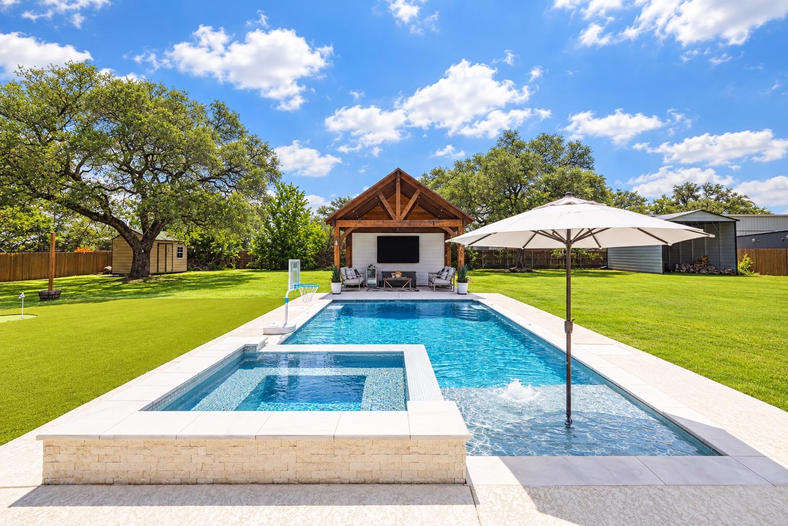 A sparkling swimming pool and integrated spa sit 