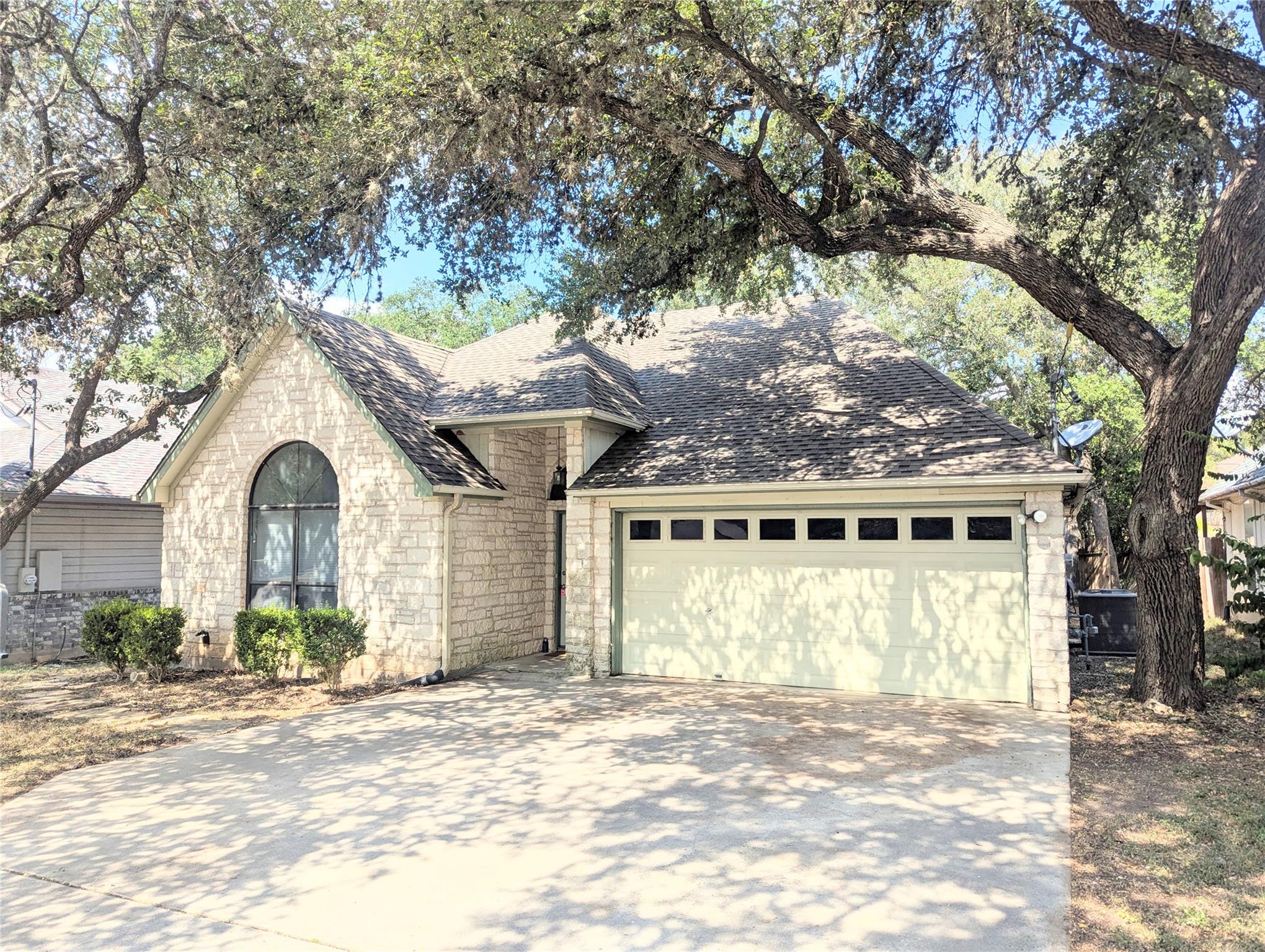Mature shade trees frame a classic stone exterior