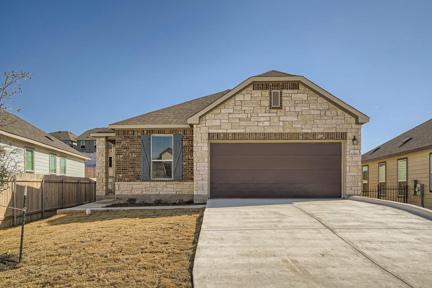A spacious concrete driveway leads to the two-car
