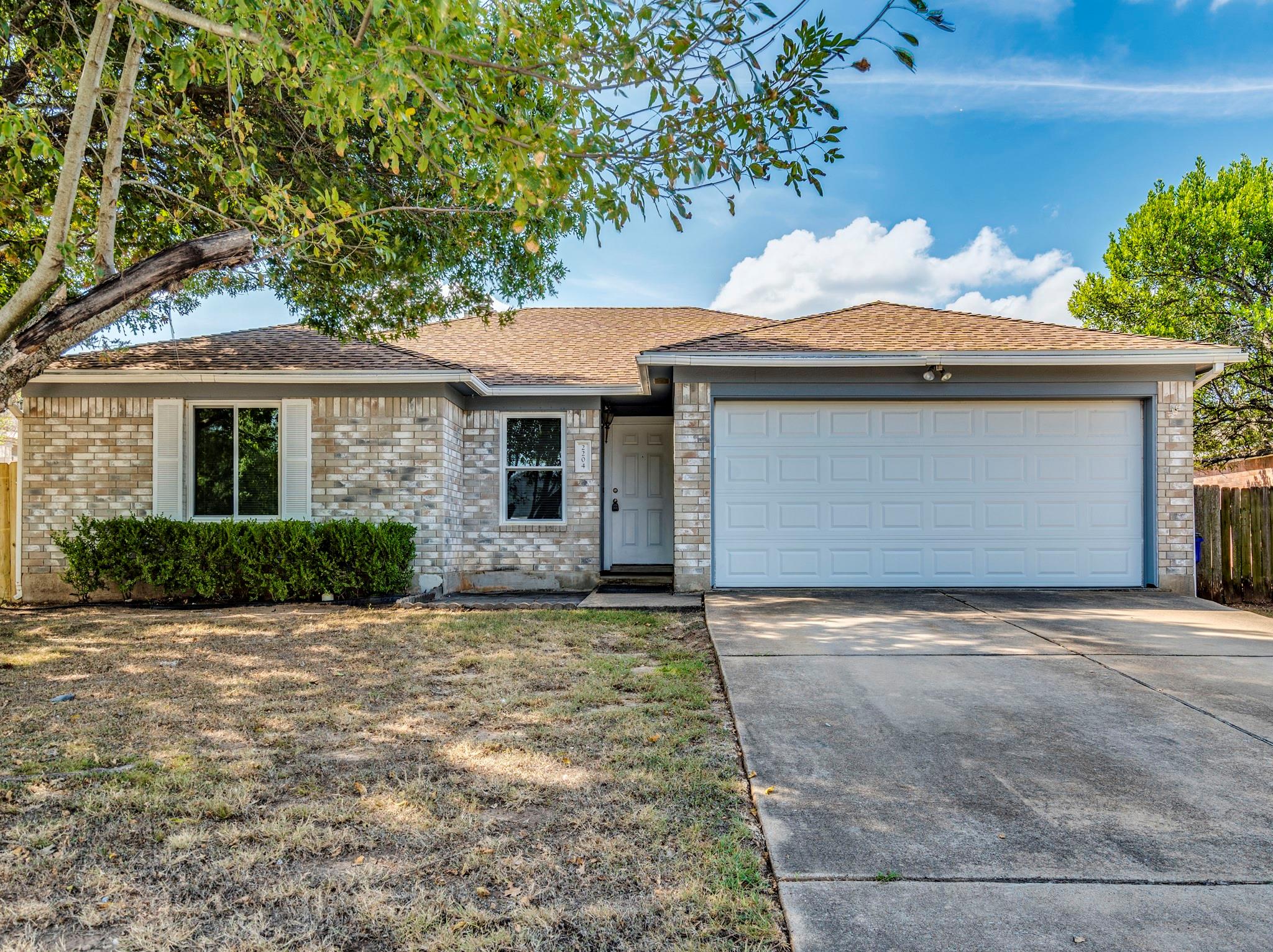 Brick accents and a classic shingle roof define t