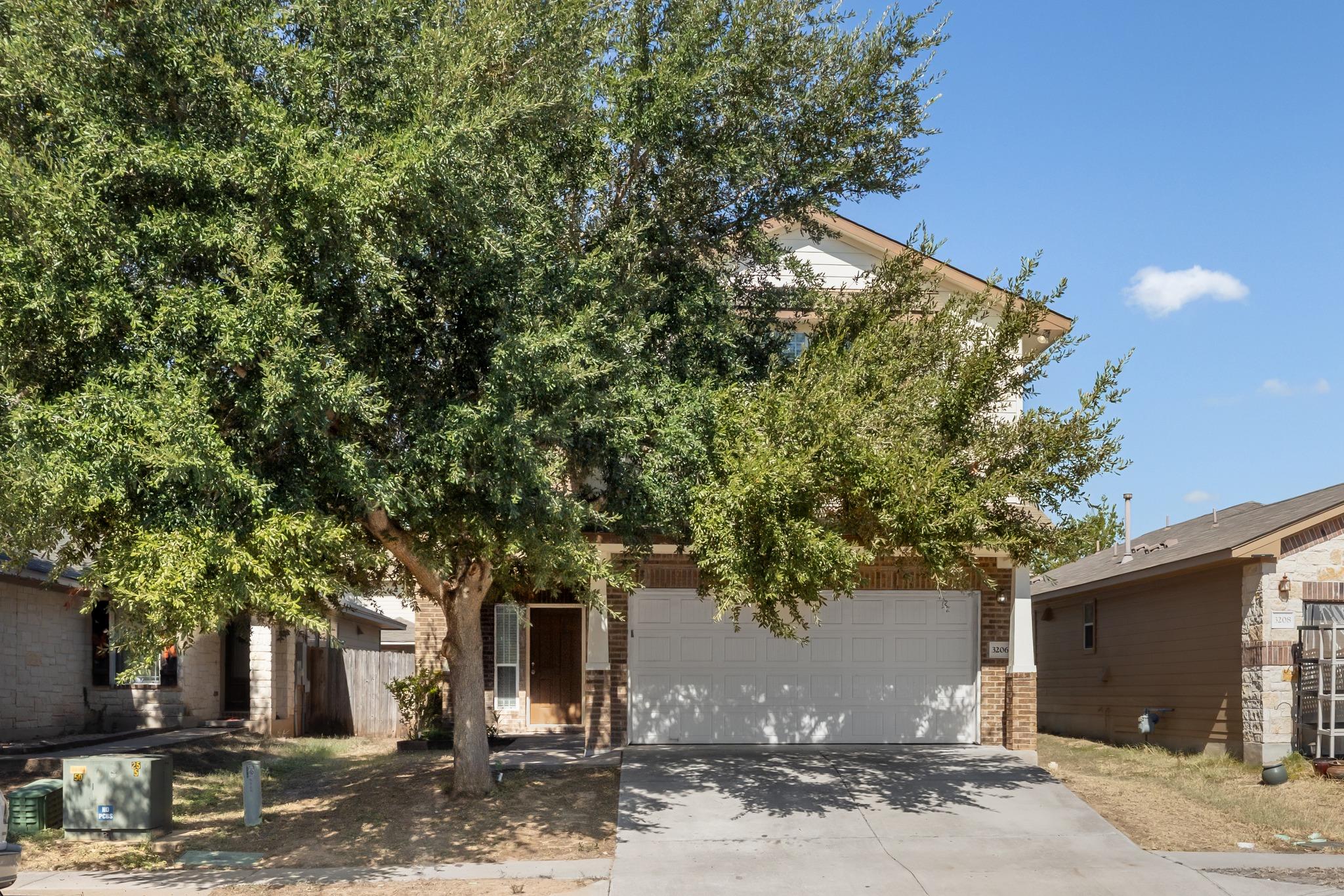 Mature trees shade the front yard and concrete dr