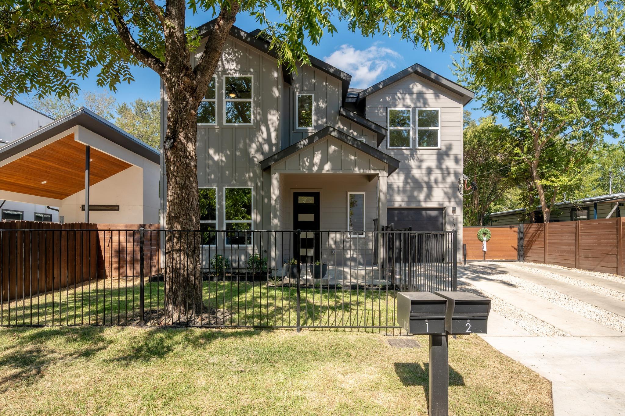 Mature trees shade the front lawn and paved drive