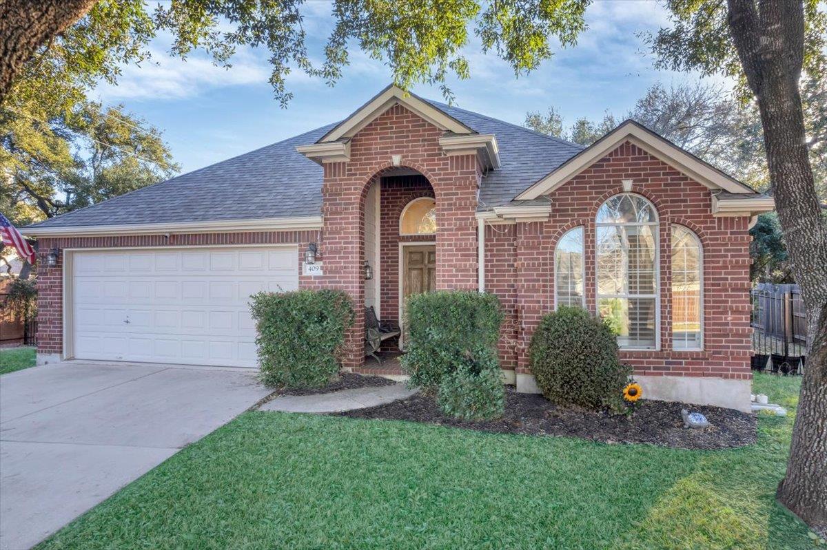 Traditional home featuring a garage, brick siding