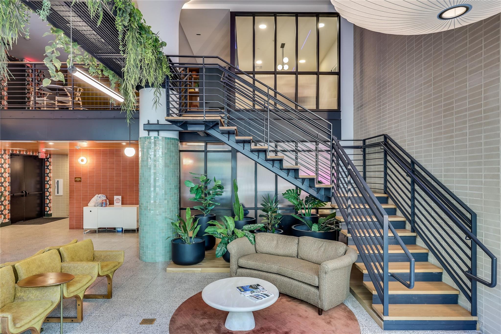 An inviting lobby features a striking staircase w