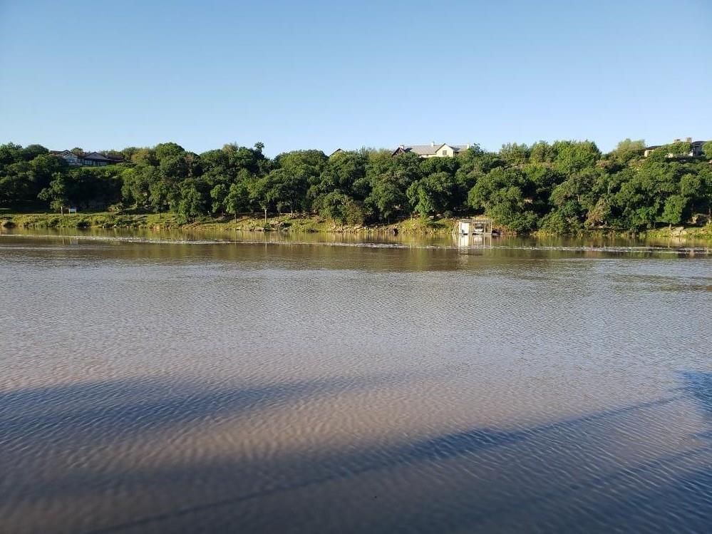 Mature trees line the gentle bank of this expansi