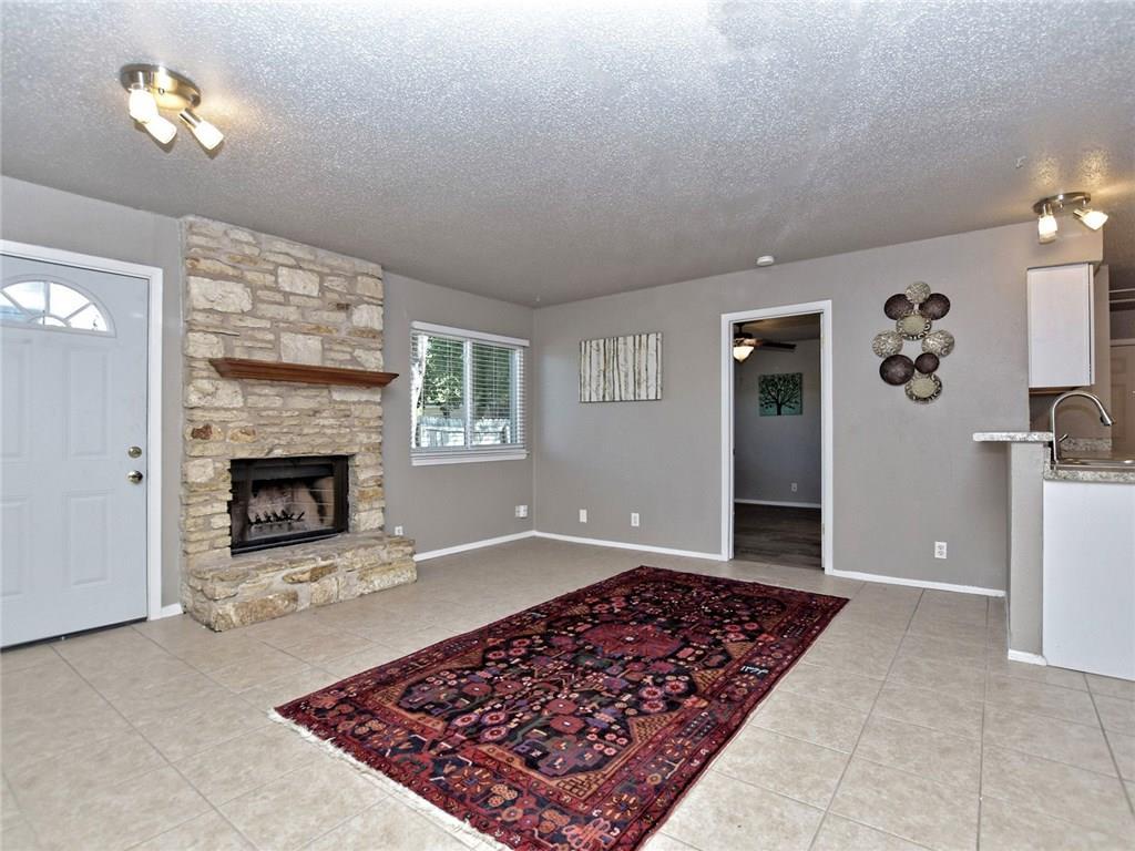 A stone fireplace anchors the open living space f