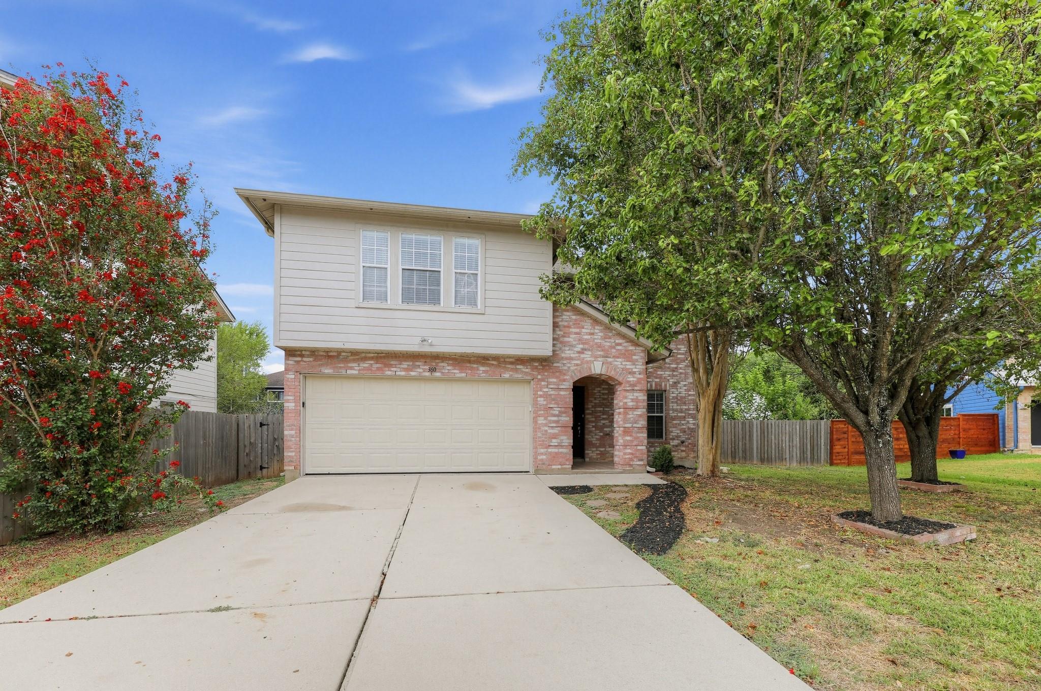 Classic brick accents and siding frame a two-stor