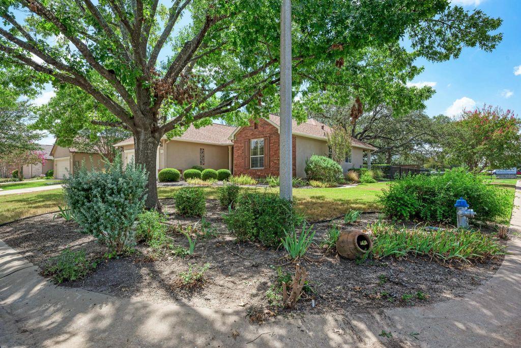 Mature shade trees and landscaped garden beds fra