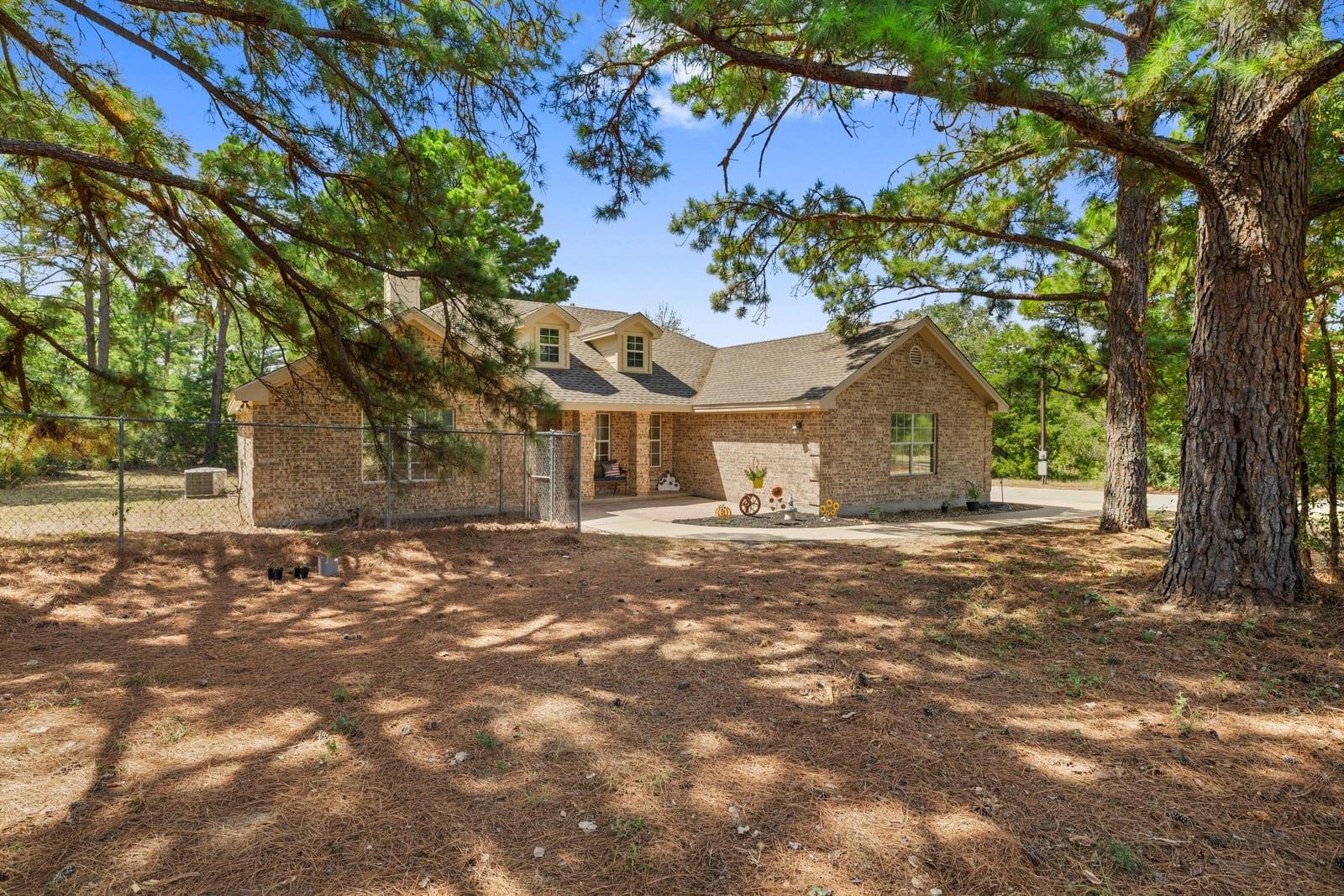 Mature trees frame a classic brick exterior compl