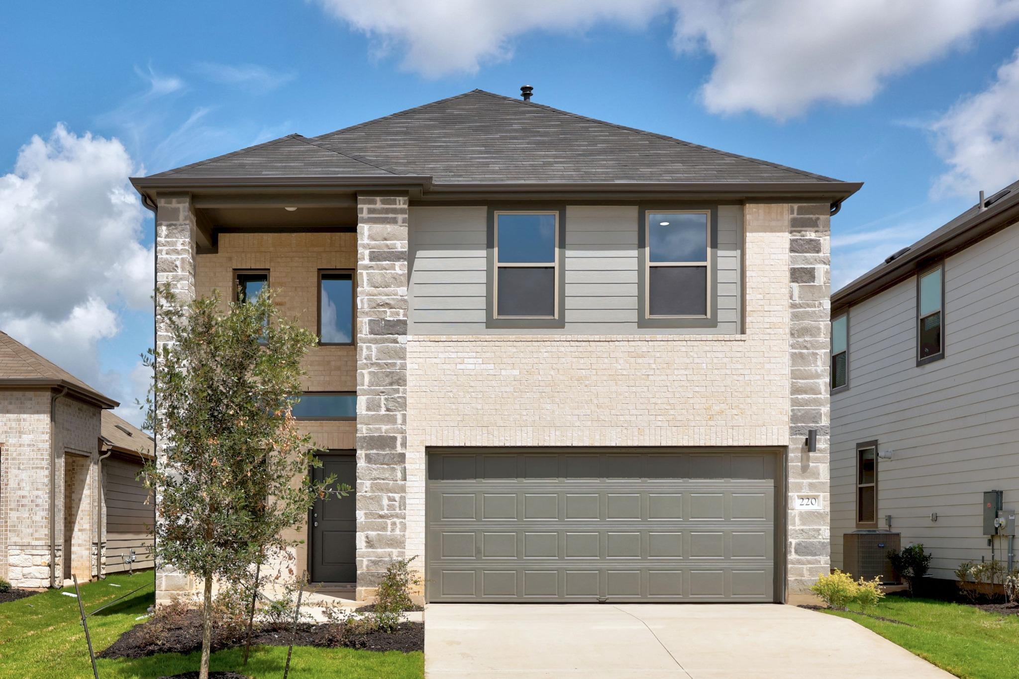 Stone accents and a classic shingle roof define t