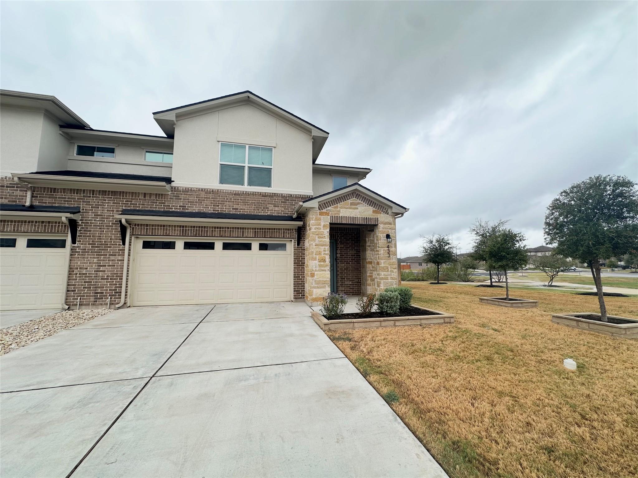 A concrete driveway leads to a modern exterior bl
