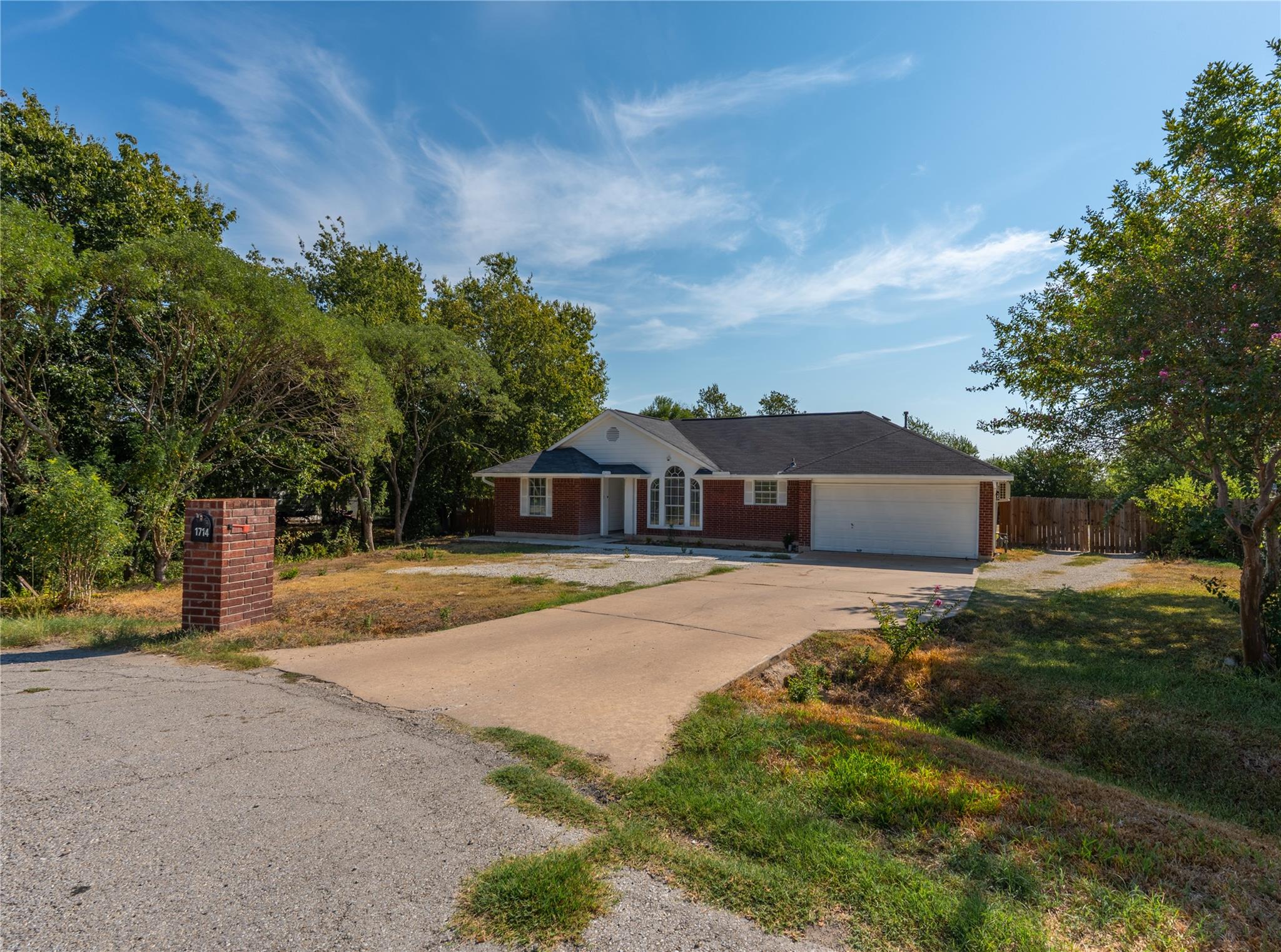 A long concrete driveway leads to this classic br