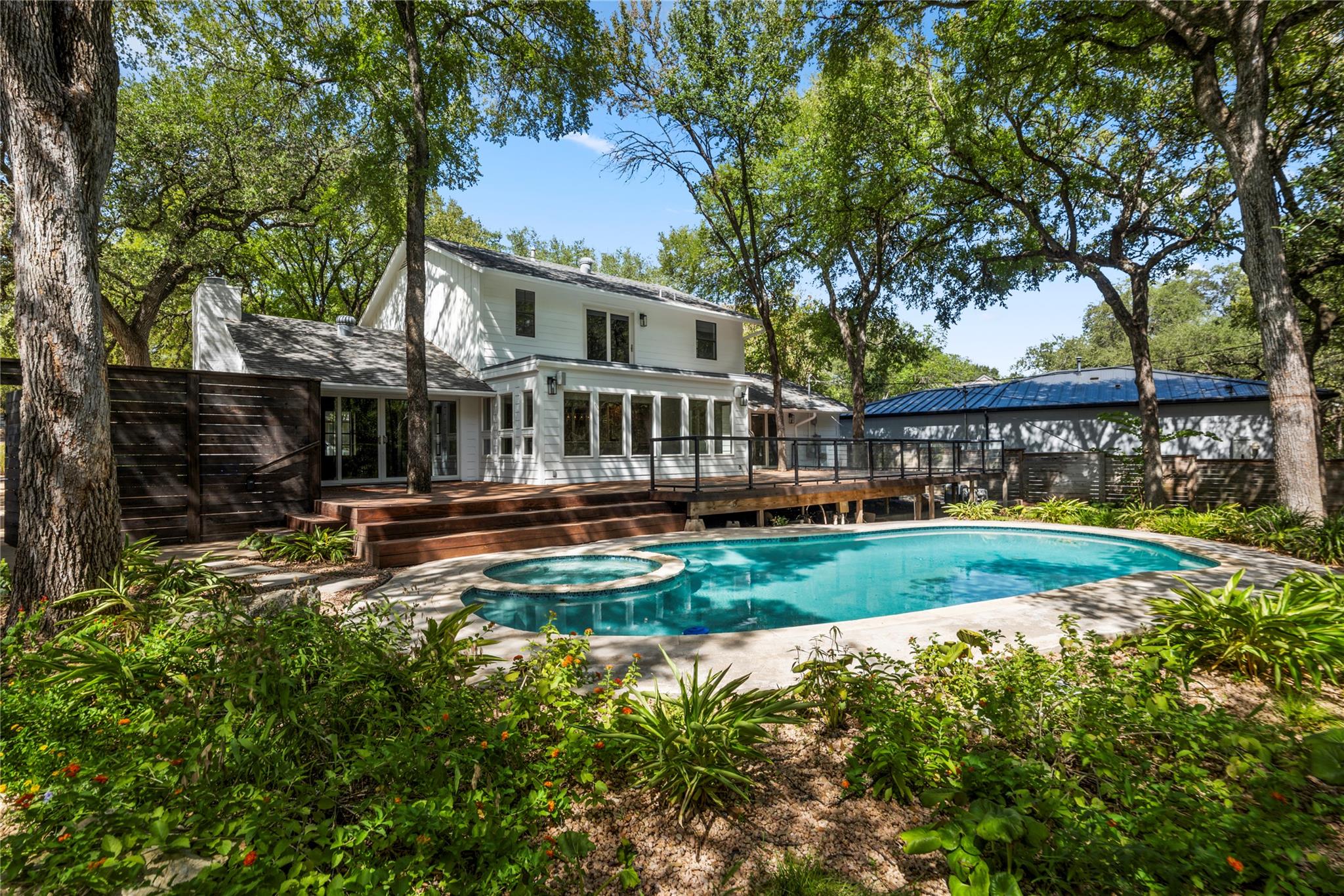 Mature trees frame a private backyard oasis compl