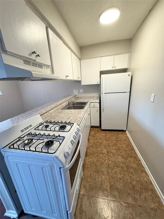 A functional kitchen features laminate flooring, 