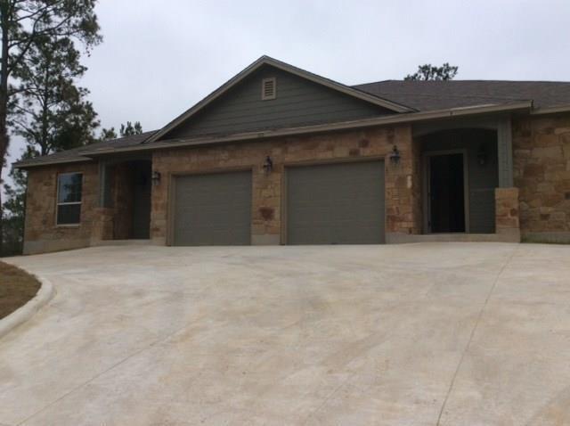 Natural stone masonry and a wide concrete drivewa