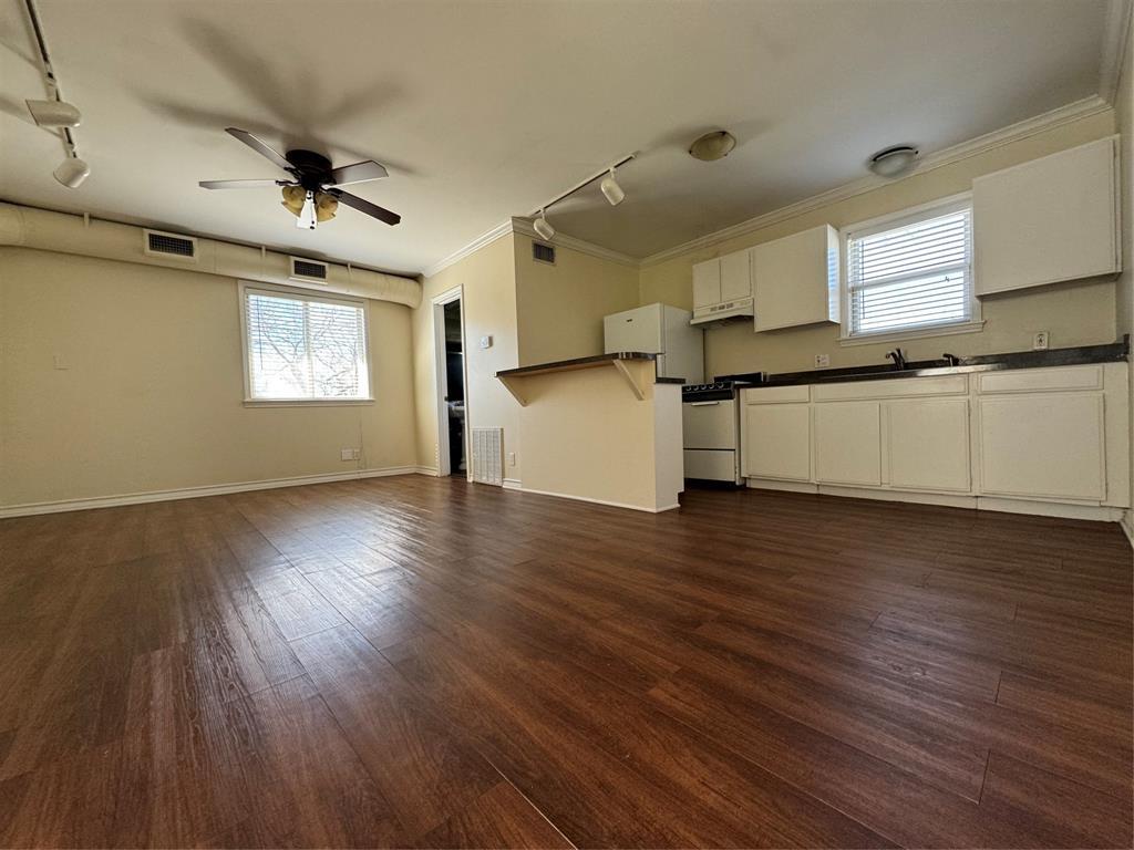 Rich wood-look flooring stretches across an open 