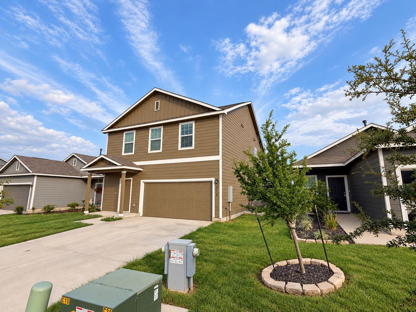 A classic two-story exterior sits behind a concre