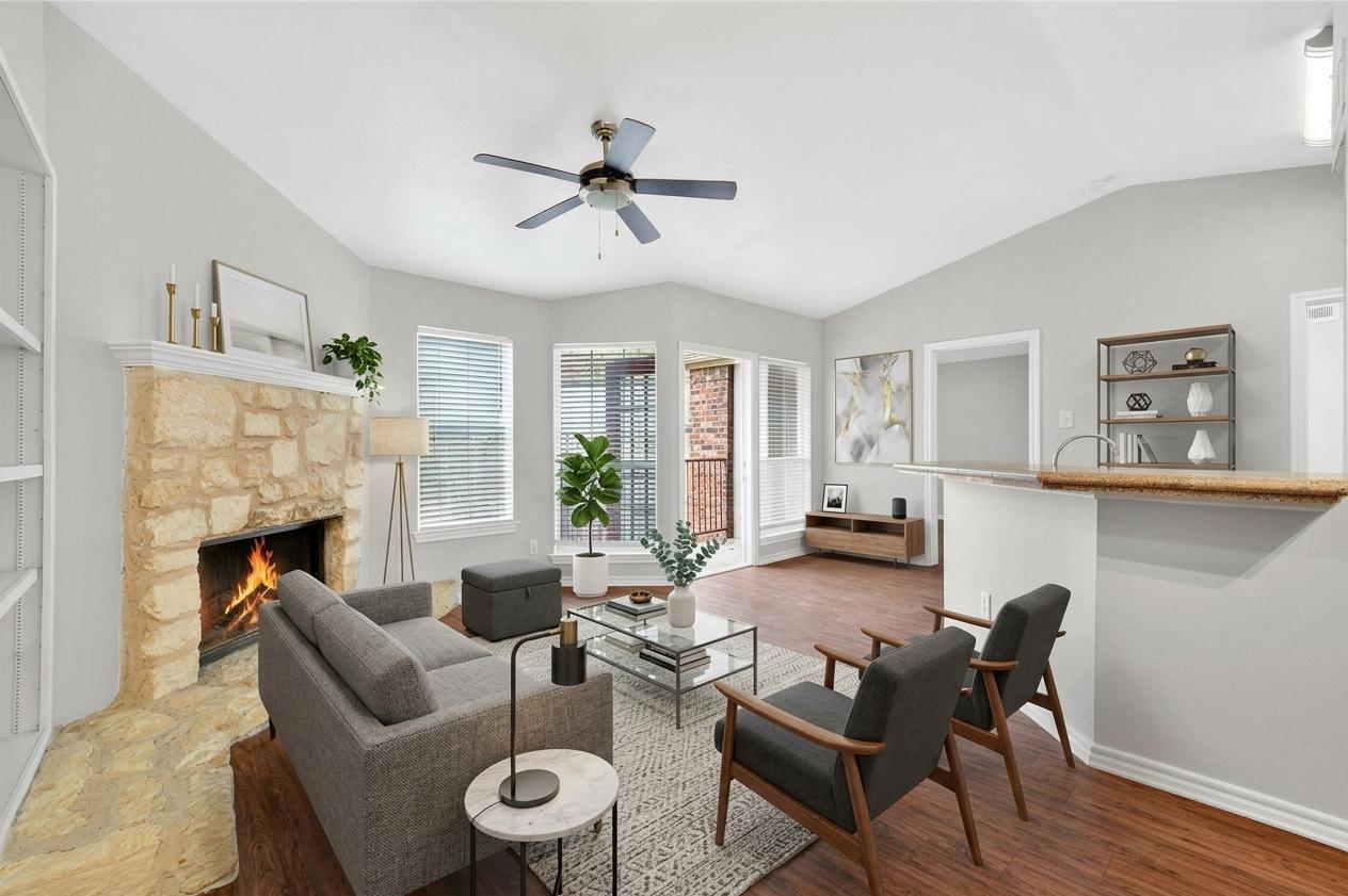 An inviting stone fireplace anchors the living ro