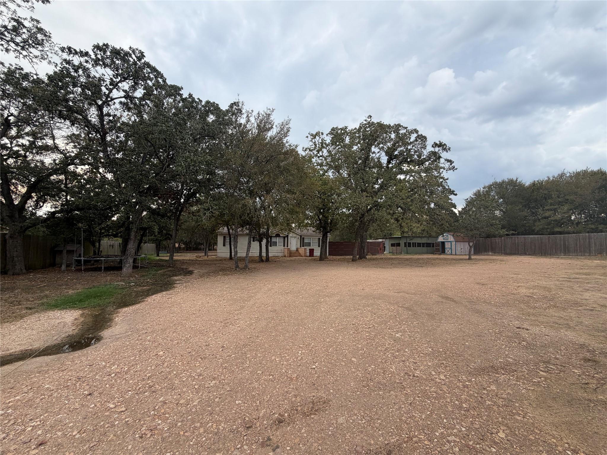 Mature trees shade a spacious clearing leading to