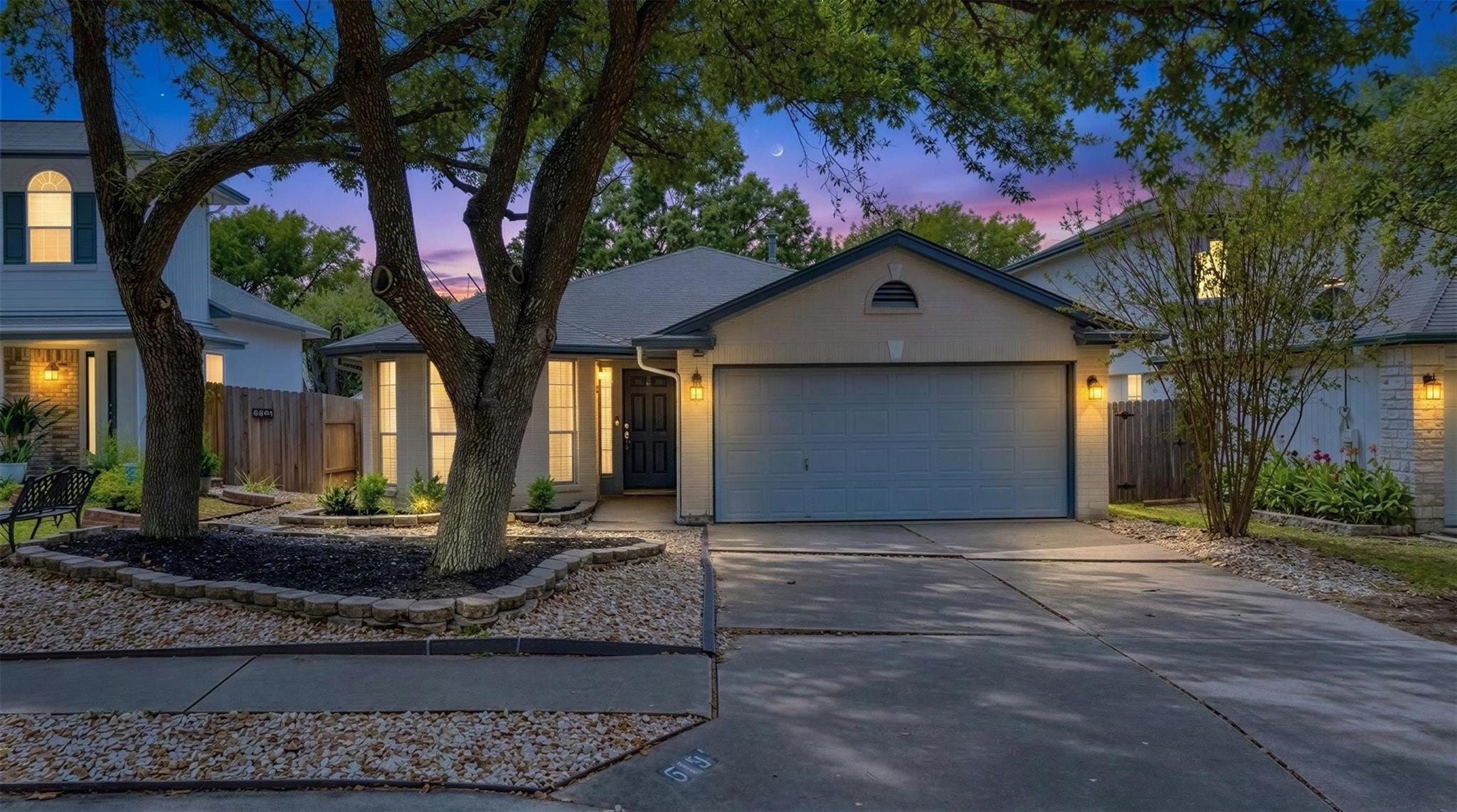 Mature trees frame a welcoming single-story exter
