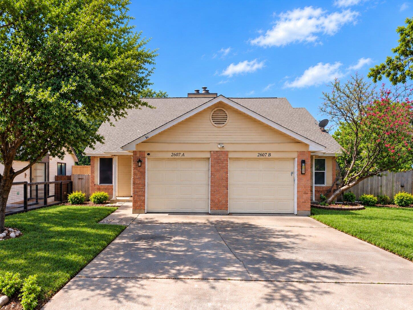 Manicured lawns flank a concrete driveway leading