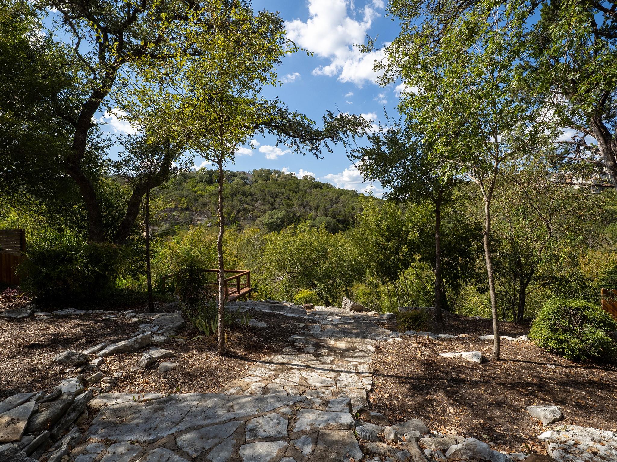 Mature trees and stone pathways frame scenic hill