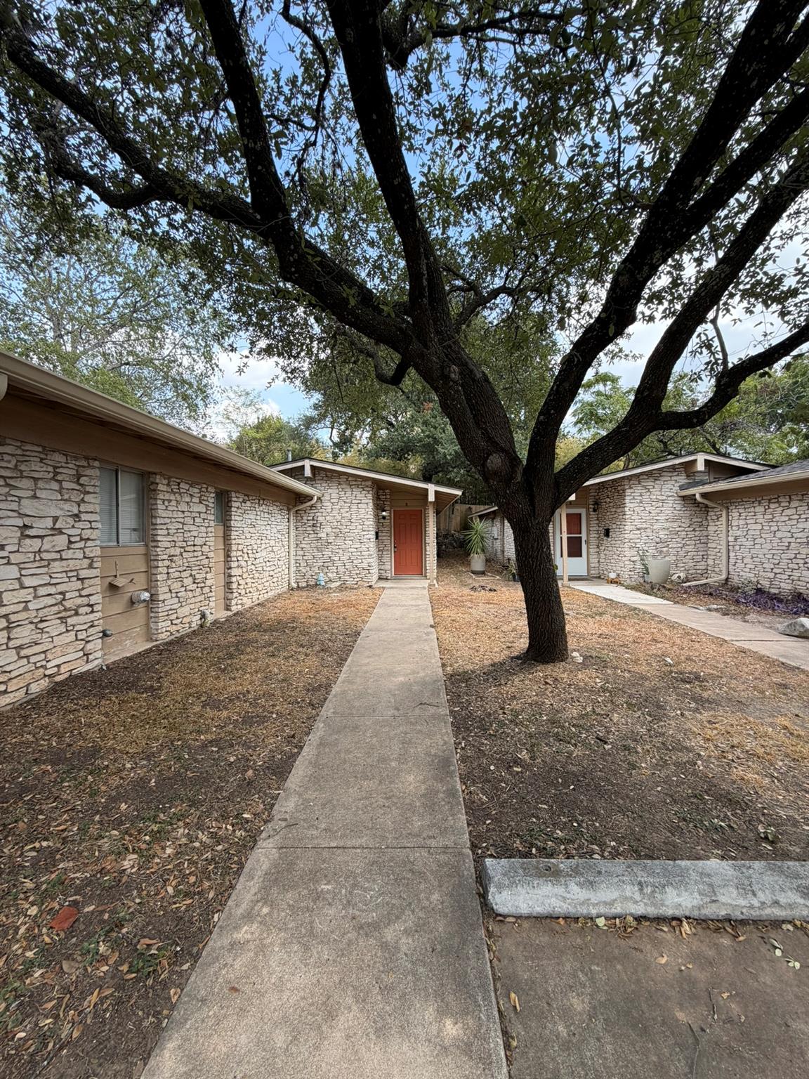 A concrete walkway leads to the entrance of this 