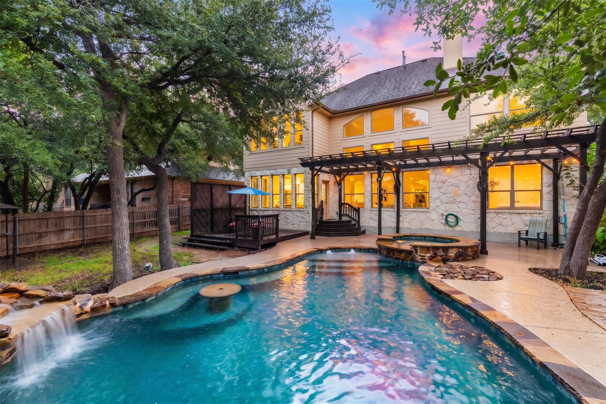 Mature trees shade a sparkling backyard pool feat