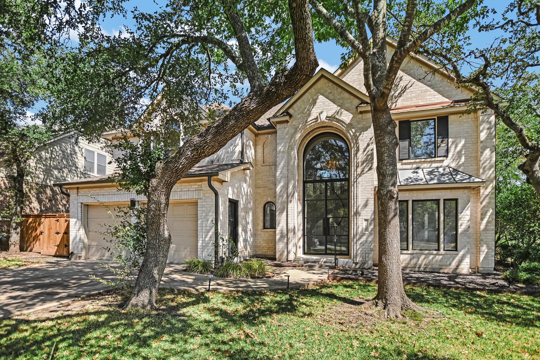 Mature trees shade a grand brick facade highlight