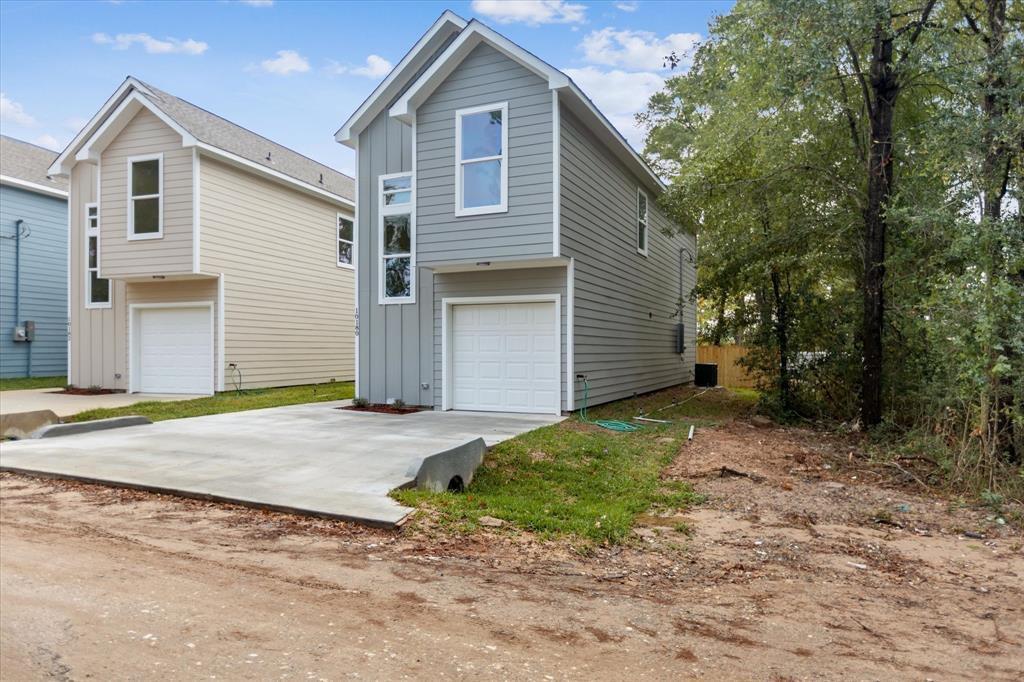 Crisp siding and a neat concrete driveway define 