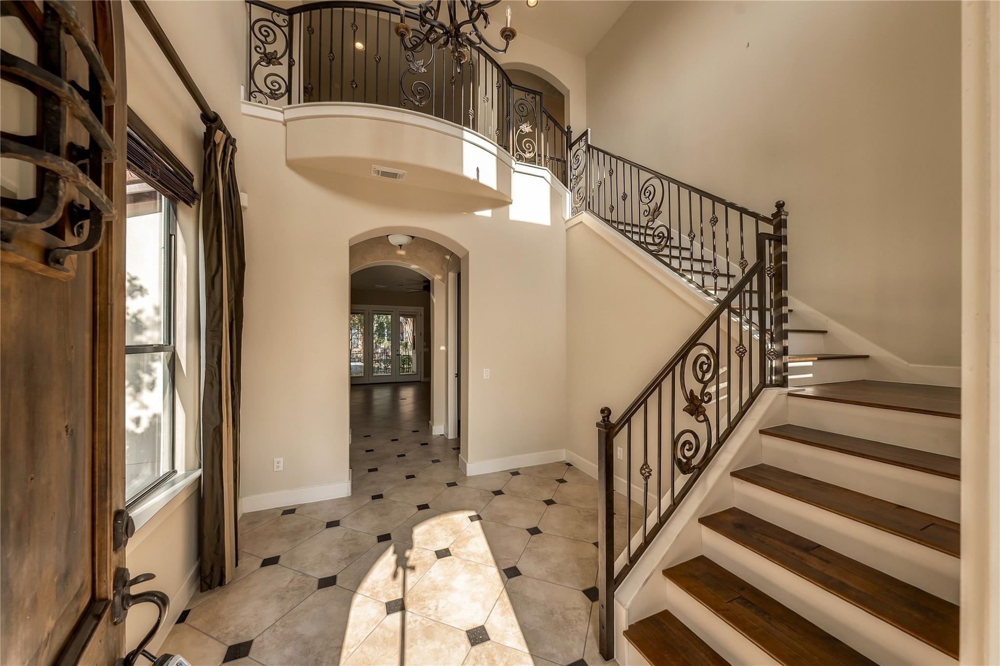 Ornate wrought iron railings flank a sweeping sta
