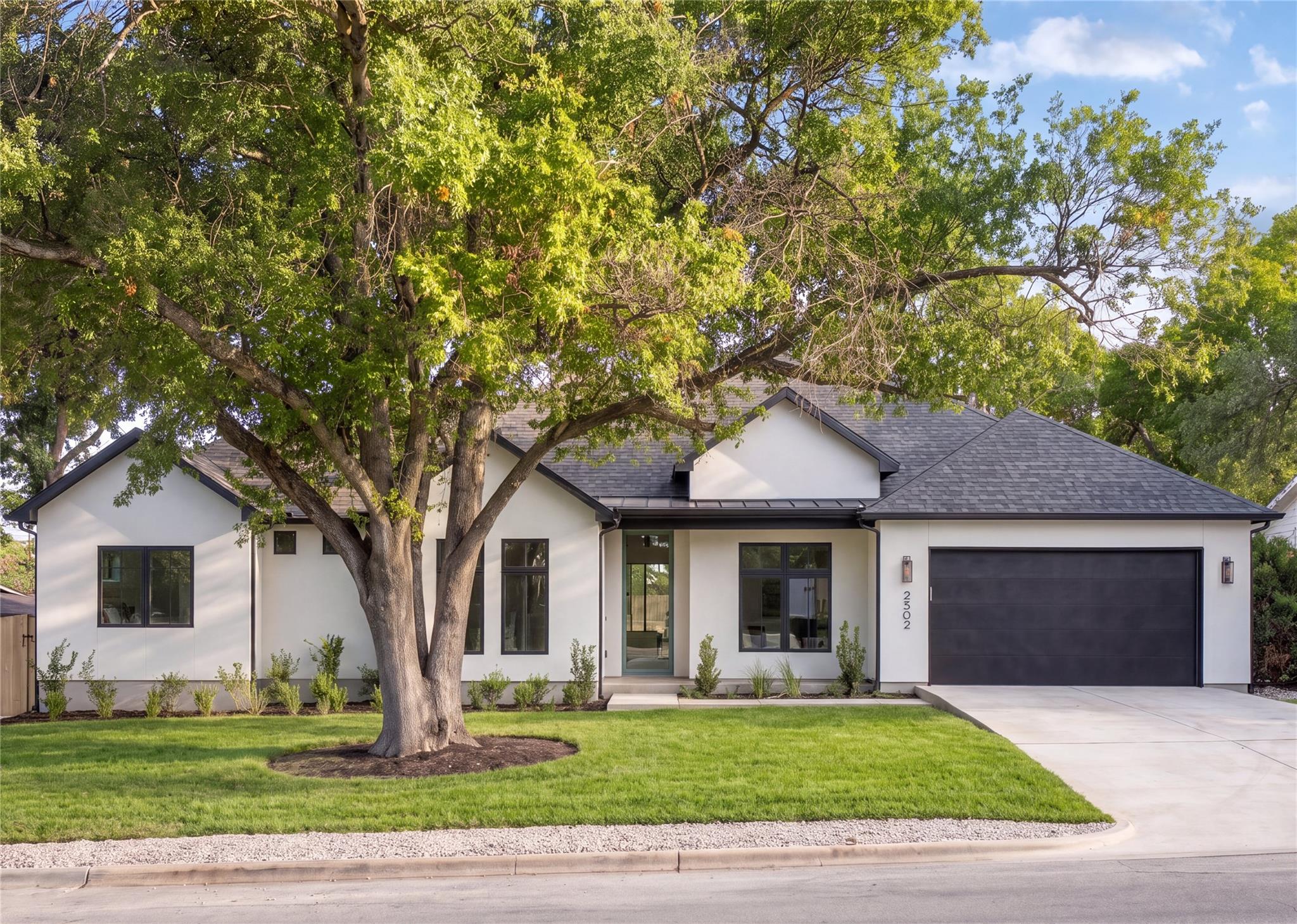 Mature trees frame the striking facade of this co