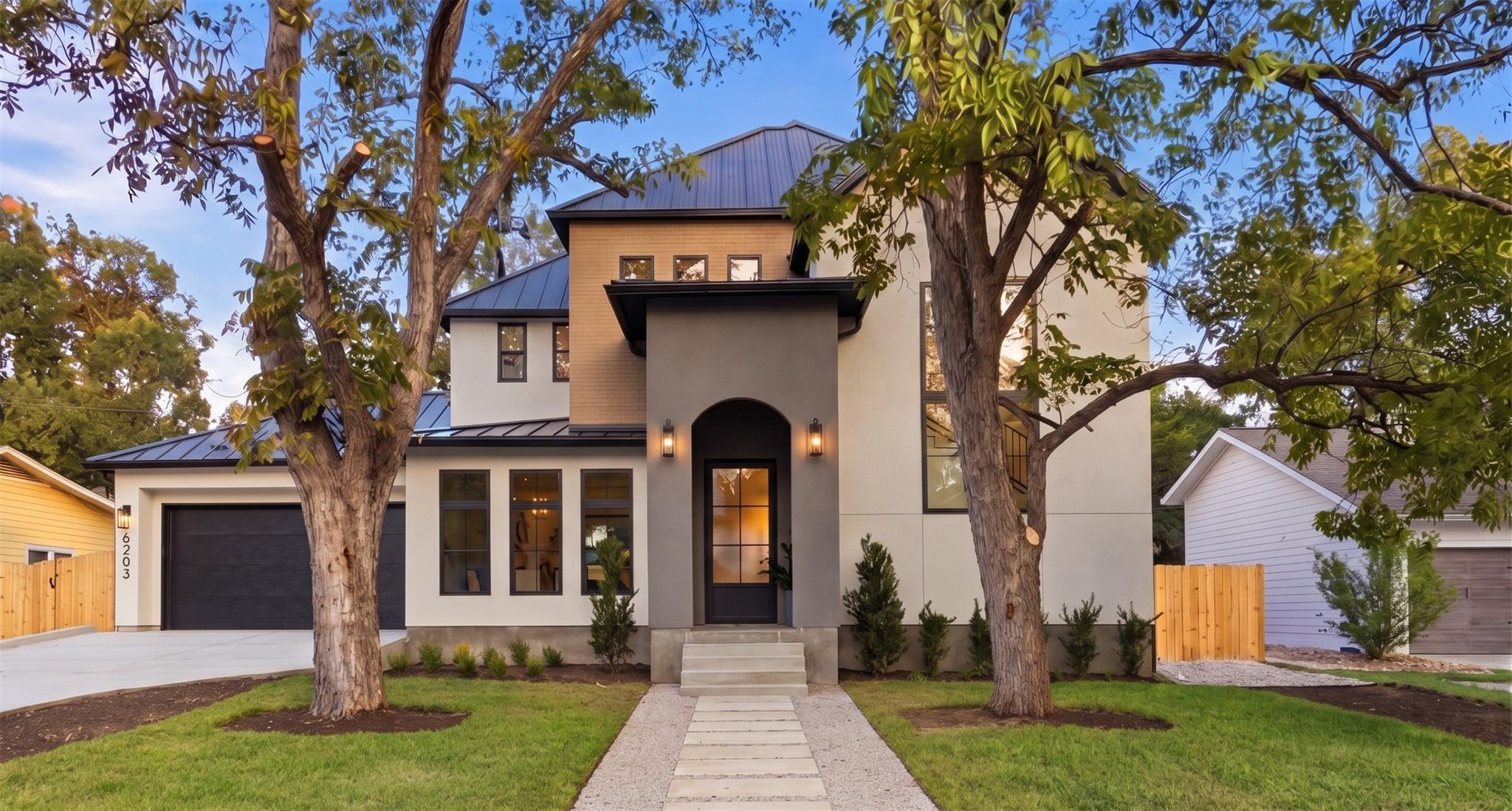 Mature trees frame the striking modern facade, hi